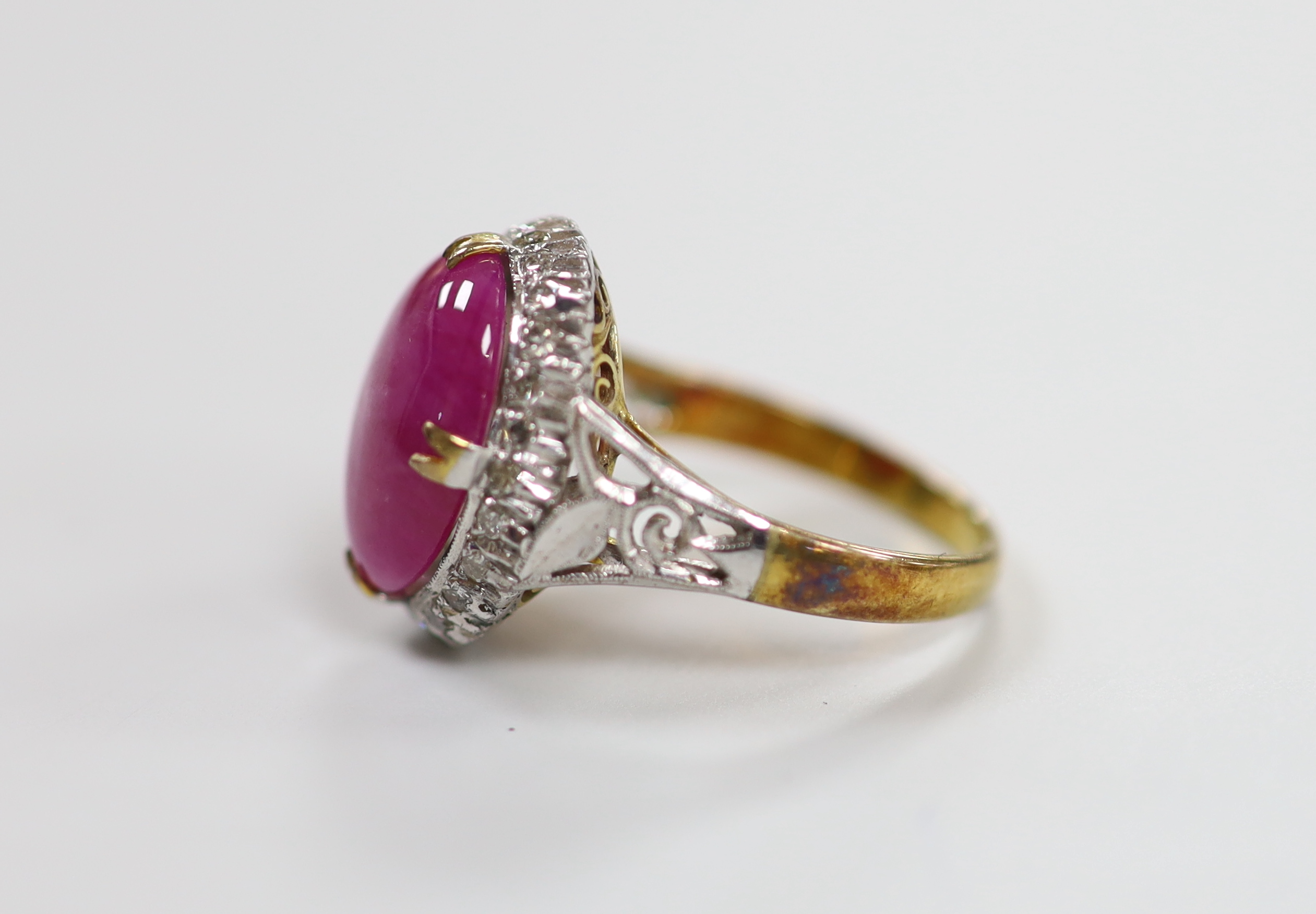 A yellow metal cabochon ruby and diamond chip set oval cluster ring, size M/N, gross weight 4.9 grams.